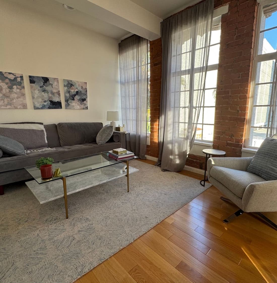 Sunlight streaming through tall brick windows onto comfortable seating in Dr. Maya Reynolds' Santa Monica practice